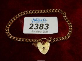 A yellow metal chain link bracelet with 18ct gold heart padlock (marked 750).