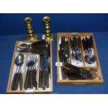 A mid century Heal's horn handled Cutlery set and a pair of brass candlesticks with pushers.