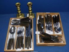 A mid century Heal's horn handled Cutlery set and a pair of brass candlesticks with pushers.