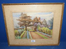 A framed and mounted Watercolour of a country cottage and garden, signed lower right T.W.