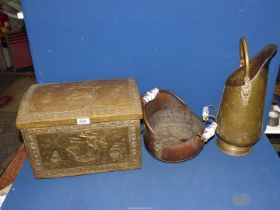 A brass coal scuttle and a copper scuttle with ceramic handles and an embossed brass coal box.