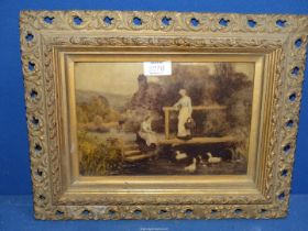 An ornately framed Crystoleum picture of ladies near a thatched cottage feeding ducks under a