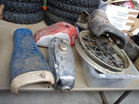 Two motorcycle fuel tanks, a swinging arm, shock absorbers, a wheel, seats, etc.