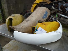 A Suzuki petrol tank plus another, a seat, an intake housing and a new white front mudguard.