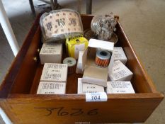 A drawer of boxed oil filters, an air filter, a carburettor and an air-cleaner, etc.