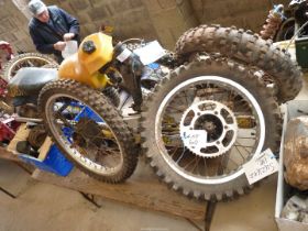 A Suzuki RM500 (1984) frame, two sets of forks, three rear arms, five wheels and tyres, a fuel tank,