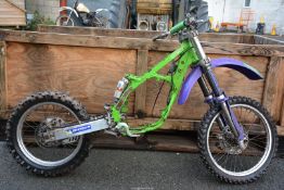 A 1997 Kawasaki KX125 K rolling chassis with disc brakes and some parts including radiators.