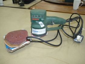 A Bosch 240 volt PEX 115A - 1, 11,000 rpm orbital sander and a good quantity of sanding discs.