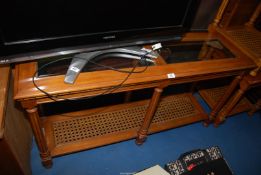 A Mahogany console/hall table having bevelled glass top and cane shelf,