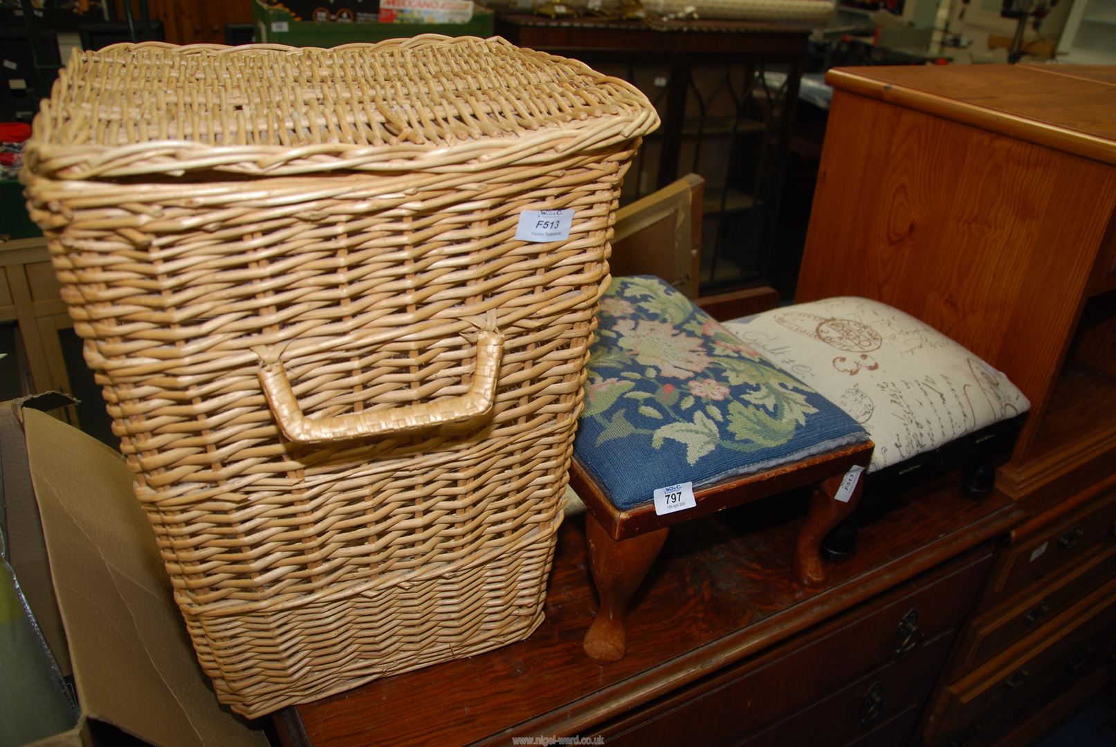 A wicker linen bin and two upholstered foot stools.