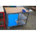 A Workbench with lockable cupboard and 4'' vice, 37'' x 22 1/2'' x 32'' high, on castors.