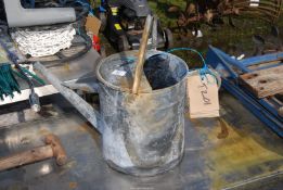 A large galvanized watering can.