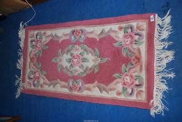 A Chinese pattern pink/cream rug 23" x 47".