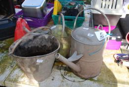 Two watering cans and a galvanised bucket.
