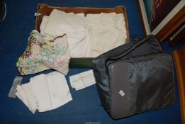 A box of linen (mostly table cloths) and a shoulder bag.
