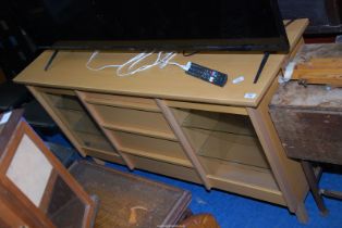 A modern light sideboard with central flight of three drawers and glass fronted cabinets to either