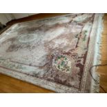 An extremely large Chinese mauve ground floral pattern bordered, patterned and fringed Carpet,