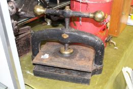 A heavy metal and brass Book Press, 16'' wide x 14 1/2'' high.