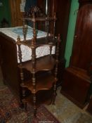 A four tier Mahogany Whatnot having turned supports to the serpentine fronted shelves and a