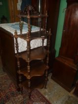 A four tier Mahogany Whatnot having turned supports to the serpentine fronted shelves and a