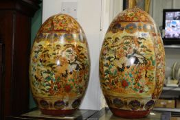 A pair of large Chinese Chinoiserie decorated ceramic Eggs decorated with birds and flora