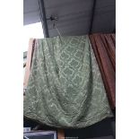 A large pair of green brocade interlined curtains having red and green tassel edging (some