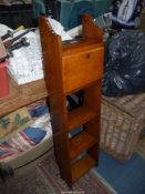 A narrow Oak floor standing Bookshelves having a fold down writing surface above,