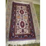 An Afghan Beluch rug in beige, blue and red shades, 69'' x 31 1/2'' including fringe.