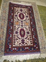 An Afghan Beluch rug in beige, blue and red shades, 69'' x 31 1/2'' including fringe.