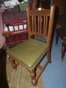 An Oak framed circa 1910/20 side Chair having turned front legs and a green leather upholstered