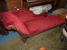 A Mahogany framed Chaise Longue standing on turned legs and upholstered in deep red velvet type