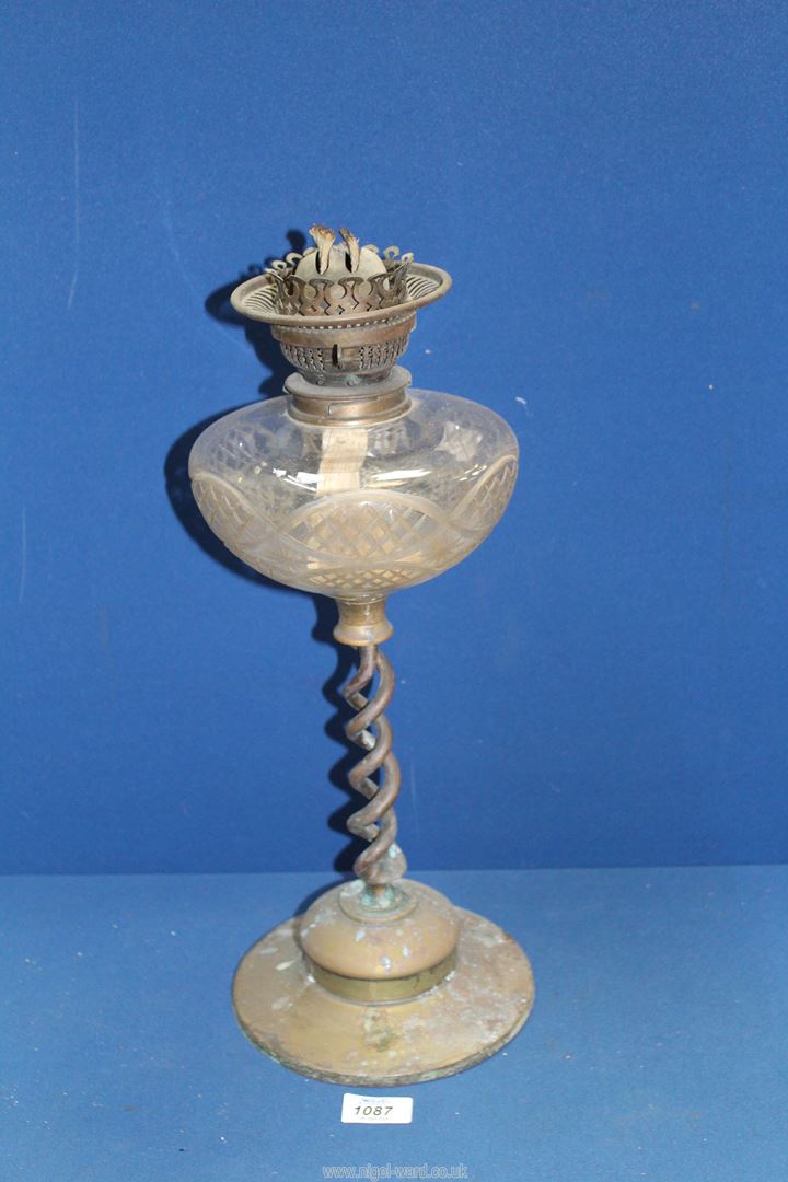 An oil lamp with cut glass reservoir, with brass base having double helix stem, 19" tall.