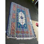 A bordered, patterned and fringed lightweight rug in bright Moorish colours with raised textures,