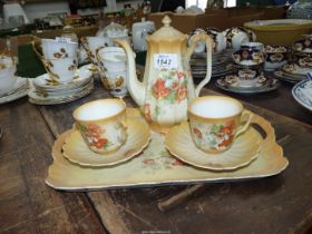 A tea for two set with tray in apricot ground with floral sprays (one cup chipped).