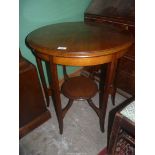 A circular Mahogany occasional table standing on shaped legs united by a lower shelf,