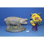 A large heavy cast metal hairy pig door stop, 13" long and a cast metal sunflower doorstop,