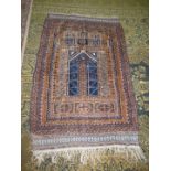 A Prayer rug in earth tones, brown and navy, 60'' x 35'' including fringe, some holes.