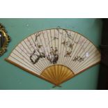 A very large hand painted Oriental Fan depicting sparrows and blossoms in a cane surround,