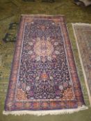 A border pattern and fringed rug with central gul on dark blue ground with all over stylised