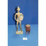 A small heavy cast metal model of an Owl and a brass figure of a tribesman beating a drum.