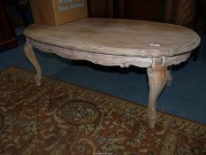 An oval limed wood effect Coffee Table standing on cabriole legs,