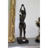A large study of a female nude with outstretched arms on a square wooden plinth/base, 27" tall.
