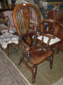 A mixed woods solid seated Armchair having turned legs and arm supports,