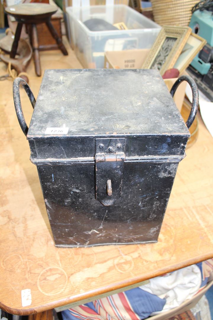 A large black metal Trunk with two elongated carrying handles, 14" tall x 11" square.