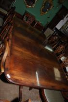 A Mahogany dining Table having double pedestals with swept reeded legs terminating in brass capped