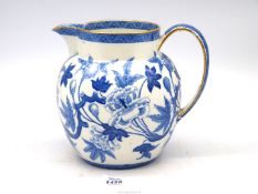 A large Wedgwood blue & white floral jug with gilt rim [damage to handle] 8" tall.