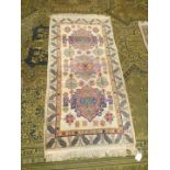 A border pattern and fringed rug with three central guls and stylised leaf border,