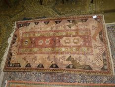 A hearth rug with central panel of stylised flowers, border with zig- zags in mustard,