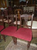 A pair of Edwardian Mahogany framed Dining Chairs having turned front legs and maroon upholstered