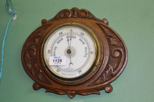 A carved oak Aneroid Barometer, 11" wide x 9" high.